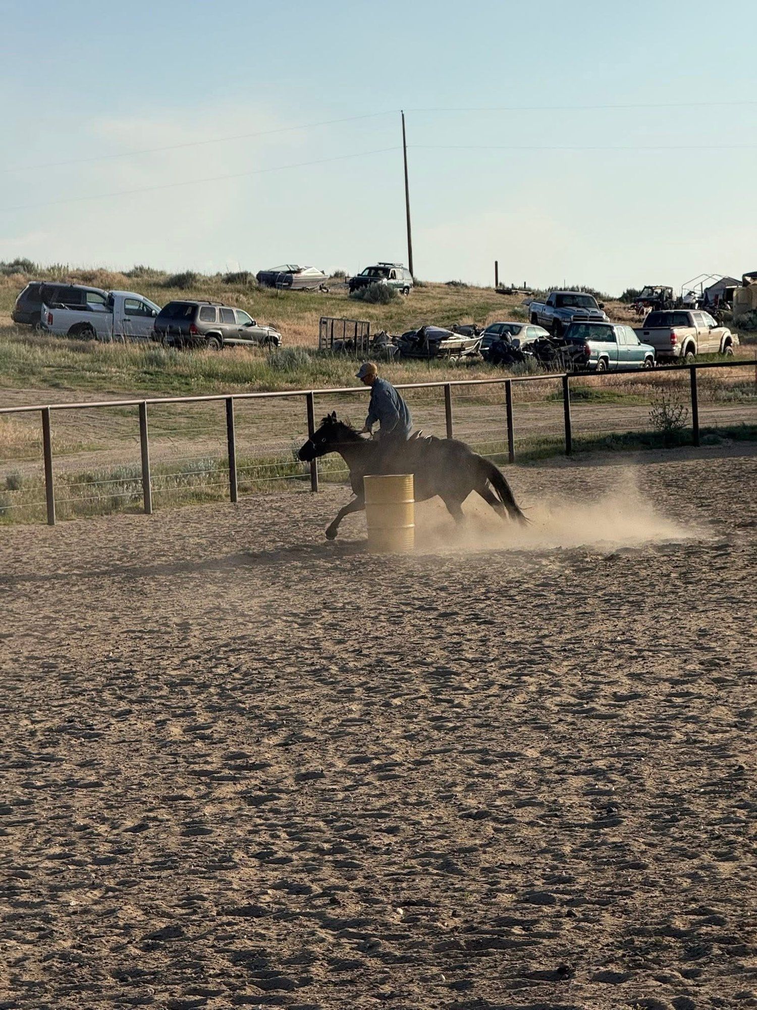 Rider rounding a barrel at speed in the outdoor arena